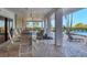 A covered outdoor patio with seating, columns, and a view of the pool and palm trees at 101 Benjamin Franklin Dr # 71, Sarasota, FL 34236