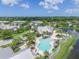Aerial shot of a community with a pool, clubhouse, and tropical landscaping offering a vibrant and inviting atmosphere at 10600 Lemon Creek Loop # 102, Englewood, FL 34224