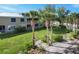 Backyard view of the screened porches, palm trees, and lawn at 10600 Lemon Creek Loop # 102, Englewood, FL 34224