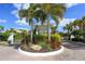 Community entrance features a roundabout, lush landscaping and a stone at 10600 Lemon Creek Loop # 102, Englewood, FL 34224