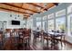 Well-lit dining area with hardwood floors, wainscoting, multiple tables, and a large TV at 10600 Lemon Creek Loop # 102, Englewood, FL 34224
