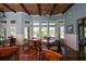 Well-lit dining area featuring hardwood floors, wainscoting, multiple tables and large windows at 10600 Lemon Creek Loop # 102, Englewood, FL 34224