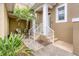 Cozy front entry featuring stairs, lush landscaping, and two white chairs at 10600 Lemon Creek Loop # 102, Englewood, FL 34224