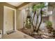 Welcoming entrance with hanging plants, a tan front door, and manicured landscaping at 10600 Lemon Creek Loop # 102, Englewood, FL 34224