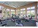 Exercise room filled with treadmills, elliptical machines, stationary bikes, and bright natural light at 10600 Lemon Creek Loop # 102, Englewood, FL 34224