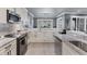 Modern kitchen boasts marble countertops, white cabinetry, and stainless steel appliances for culinary enthusiasts at 10600 Lemon Creek Loop # 102, Englewood, FL 34224