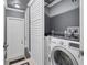Convenient laundry room featuring a front load washer, dark countertop and storage at 10600 Lemon Creek Loop # 102, Englewood, FL 34224