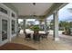 Covered patio with comfortable seating and views of lush landscaping and beautiful buildings at 10600 Lemon Creek Loop # 102, Englewood, FL 34224