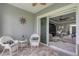 Covered patio with stone floor and white wicker furniture at 10600 Lemon Creek Loop # 102, Englewood, FL 34224