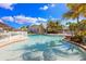 Serene community pool with clear blue water, palm trees, and comfortable seating, perfect for relaxation and socializing at 10600 Lemon Creek Loop # 102, Englewood, FL 34224