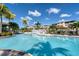 Community swimming pool featuring sun loungers and umbrellas for relaxation and shaded comfort on a bright sunny day at 10600 Lemon Creek Loop # 102, Englewood, FL 34224