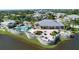 An aerial view of a community pool surrounded by seating, lush landscaping, and a lake providing a resort-style feel at 10600 Lemon Creek Loop # 102, Englewood, FL 34224