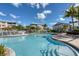 Community pool with clear blue water, surrounded by palm trees, lounge seating and a tranquil setting for residents at 10600 Lemon Creek Loop # 102, Englewood, FL 34224