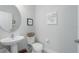 Stylish powder room features a pedestal sink, tiled floors, and decorative wall art at 10919 Blue Magnolia Ln, Parrish, FL 34219