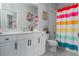 Bathroom features a vibrant shower curtain, white vanity, and a sink with decor at 10919 Blue Magnolia Ln, Parrish, FL 34219