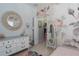 Charming bedroom featuring floral wallpaper, closet, and a round mirror at 10919 Blue Magnolia Ln, Parrish, FL 34219