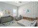 Charming bedroom with a dinosaur theme, a cozy armchair, and ample natural light at 10919 Blue Magnolia Ln, Parrish, FL 34219
