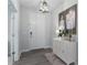 Bright entryway with gray wood floors, a decorative cabinet with fresh flowers, and artwork creating a welcoming ambiance at 10919 Blue Magnolia Ln, Parrish, FL 34219