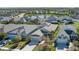 Aerial neighborhood view with houses, green spaces, and a peaceful lake in the background showcasing community living at 10919 Blue Magnolia Ln, Parrish, FL 34219