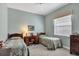 Cozy bedroom with twin beds, desk, and window offering natural light at 11031 Hyacinth Pl, Lakewood Ranch, FL 34202