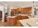 A bright kitchen featuring wood cabinets, quartz countertops, and an island with a breakfast bar at 11031 Hyacinth Pl, Lakewood Ranch, FL 34202