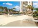 Lido Beach Club pool area featuring lounge chairs, umbrellas, and lush landscaping for a serene experience at 1212 Benjamin Franklin Dr # 1103, Sarasota, FL 34236