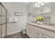 Bathroom featuring double vanity, granite countertop, walk-in shower, and decorative flower arrangement at 12423 Blue Hill Trl, Lakewood Ranch, FL 34211