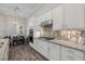 Modern kitchen featuring granite countertops, mosaic backsplash, and stainless steel appliances at 12423 Blue Hill Trl, Lakewood Ranch, FL 34211