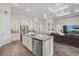 Open-concept kitchen with stainless steel appliances, island seating, and seamless flow into the living area at 12423 Blue Hill Trl, Lakewood Ranch, FL 34211
