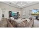 Spacious living room with tray ceilings, comfortable seating, and sliding glass doors to the outdoors at 12423 Blue Hill Trl, Lakewood Ranch, FL 34211