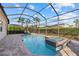 Screened-in pool and spa with a brick-paver deck, surrounded by lush landscaping at 12423 Blue Hill Trl, Lakewood Ranch, FL 34211