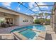 Screened-in pool and spa with an outdoor kitchen and seating area at 12423 Blue Hill Trl, Lakewood Ranch, FL 34211