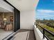 Tiled balcony with railing offering scenic views of the city and waterfront beyond the mature trees at 1255 N Gulfstream Ave # 407, Sarasota, FL 34236