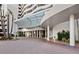 A grand building entrance featuring a covered driveway, decorative brickwork, and well-maintained landscaping at 1255 N Gulfstream Ave # 407, Sarasota, FL 34236