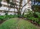 Relax in a tranquil courtyard with lush plants, bench seating, and natural shade near the building at 1255 N Gulfstream Ave # 407, Sarasota, FL 34236