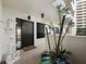 Welcoming condo entrance with modern black door, stylish plants, and tiled floor, offering an elegant appeal at 1255 N Gulfstream Ave # 407, Sarasota, FL 34236