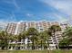 Exterior shot of a high-rise condo building with many balconies and tropical trees at 1255 N Gulfstream Ave # 407, Sarasota, FL 34236