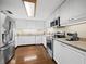 Bright kitchen with white cabinets, stainless steel appliances, and hardwood floors at 1255 N Gulfstream Ave # 407, Sarasota, FL 34236
