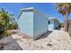 Exterior view of the blue shed, with lattice trim, gravel base and located in the backyard at 1708 Wharf Rd, Sarasota, FL 34231