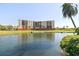 Serene lakeside view of condo building, beautifully situated near lush green spaces and mature palm trees at 2311 14Th W Ave # 108, Palmetto, FL 34221