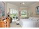 Bright main bedroom with a king bed, dresser, sitting area, and sliding glass doors to the patio at 2937 Seasons Blvd, Sarasota, FL 34240