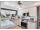 Well-lit kitchen with white cabinets, granite countertops, stainless appliances, and a view to the outdoors at 3746 Glen Oaks Manor Dr, Sarasota, FL 34232