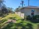 Backyard view showcasing a green lawn, partial home exterior, and natural landscape at 3799 Laredo Ave, North Port, FL 34288