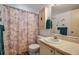 This is a bathroom with neutral decor, featuring a sink, toilet and shower with decorative shower curtain at 3860 Ironwood Ln # 503G, Bradenton, FL 34209