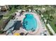 Aerial view of a kidney-shaped pool with people swimming and lounging by the pool in chairs at 3860 Ironwood Ln # 503G, Bradenton, FL 34209