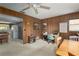 Cozy living room with wood paneling, an office area, and a view into the kitchen at 3960 Sunshine Ave, Sarasota, FL 34231