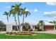 Beautiful single-story home with a white roof, a lush lawn, and several palm trees at 432 Partridge Cir, Sarasota, FL 34236