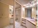 Well-lit bathroom with a glass-enclosed shower, dual sinks, and white tile flooring at 4440 Fairways Blvd # 407, Bradenton, FL 34209