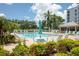Community pool with lounge chairs, umbrellas, and palm trees, perfect for relaxing at 4440 Fairways Blvd # 407, Bradenton, FL 34209
