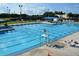 Community swimming pool with clear blue water, lanes, lifeguard chair, and lounge chairs at 4440 Fairways Blvd # 407, Bradenton, FL 34209